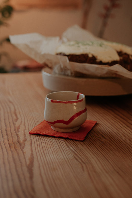 6 cm slightly fluted cup with red waves by linda bredenbekk